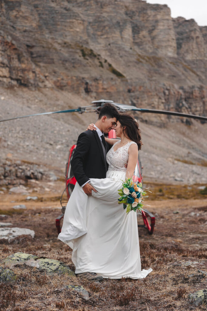 Bride and groom in front of a helicopter